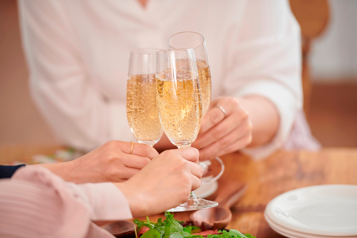 Brinde com taças de espumante em uma noite de vinho e petiscos entre amigos. 