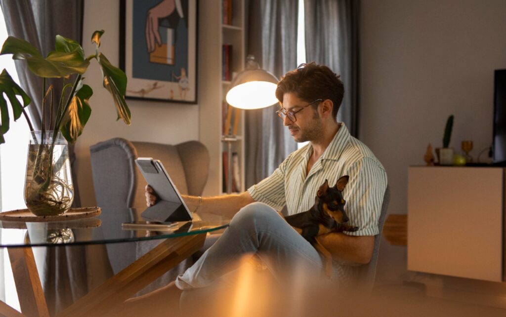 Homem trabalhando home office com cachorro | Crédito: Freepik