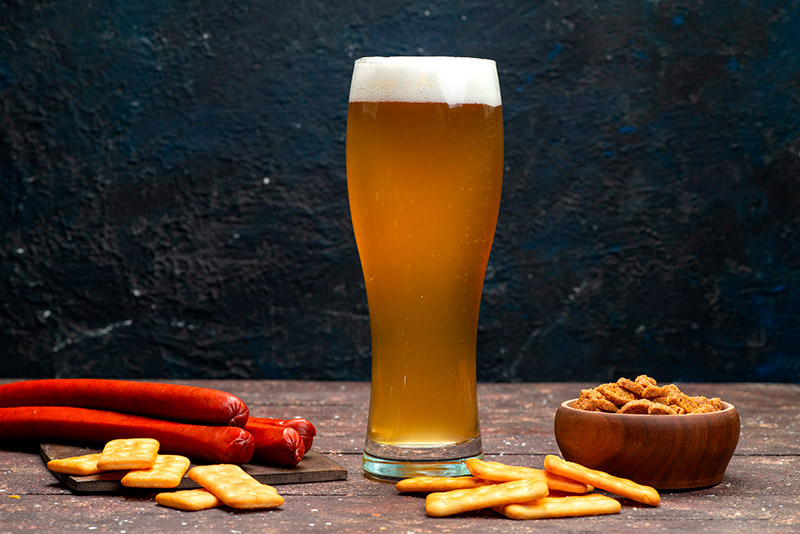 Copo tulipa com cerveja clara e espuma cremosa, formato curvado que valoriza aroma e retenção de espuma, comum entre tipos de copos para drinks e cervejas especiais 