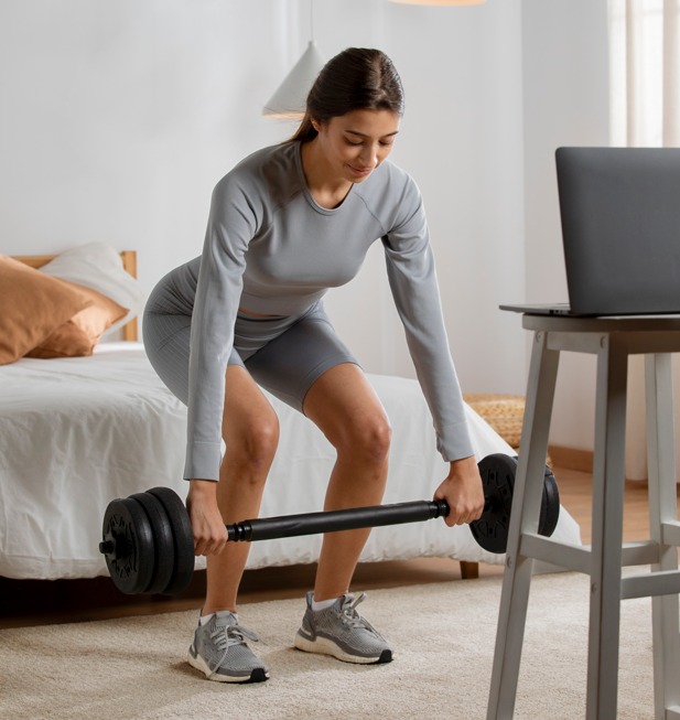 Mulher treinando com pesos em casa | Crédito: Freepik